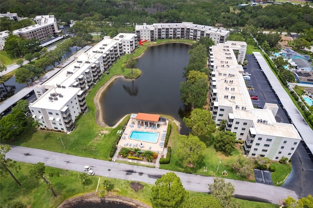 drone / aerial view of apartment complex / building, a large body of water, and a pool area