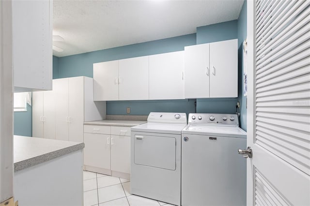 laundry room with independent washer and dryer, cabinet space, a textured ceiling, and light tile patterned floors