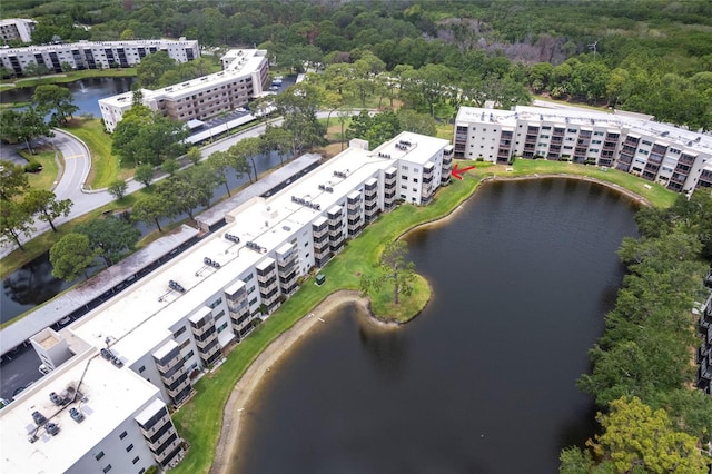 bird's eye view of apartment complex, a forest, and a large body of water