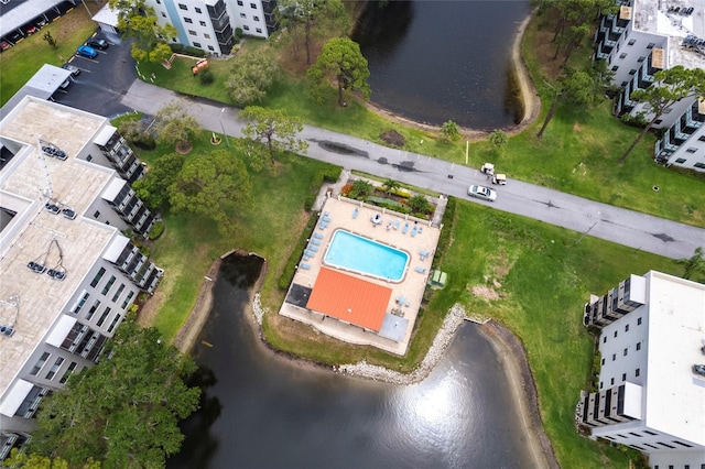 aerial view of property and surrounding area with a large body of water, apartment complex, and a pool area