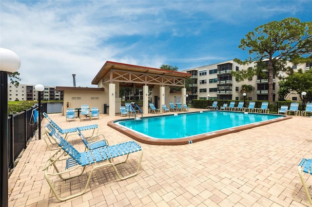 community pool with fence and a patio area