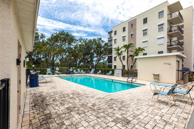 community pool with fence and a patio