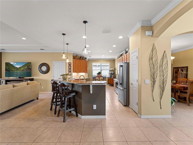 5461 White Ibis Dr, North Port, FL 34287 - kitchen featuring high quality fridge, crown molding, a peninsula, a breakfast bar, and brown cabinets