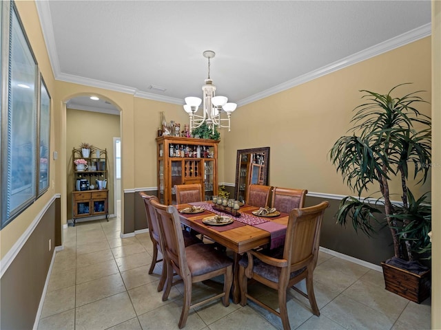 5461 White Ibis Dr, North Port, FL 34287 - dining area with arched walkways, a chandelier, ornamental molding, light tile patterned floors, and baseboards