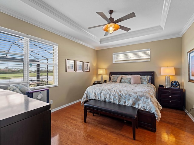 5461 White Ibis Dr, North Port, FL 34287 - bedroom with a tray ceiling, multiple windows, wood finished floors, and crown molding