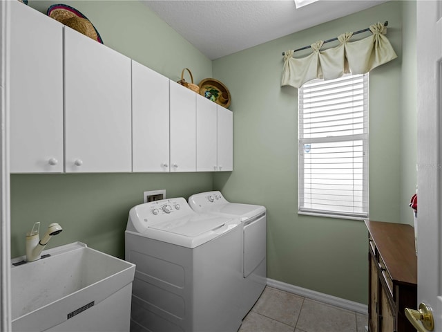 5461 White Ibis Dr, North Port, FL 34287 - washroom featuring cabinet space, washing machine and clothes dryer, a textured ceiling, light tile patterned floors, and baseboards