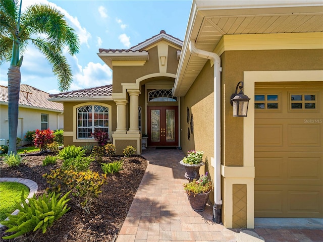 5461 White Ibis Dr, North Port, FL 34287 - entrance to property with french doors, stucco siding, an attached garage, and a tile roof