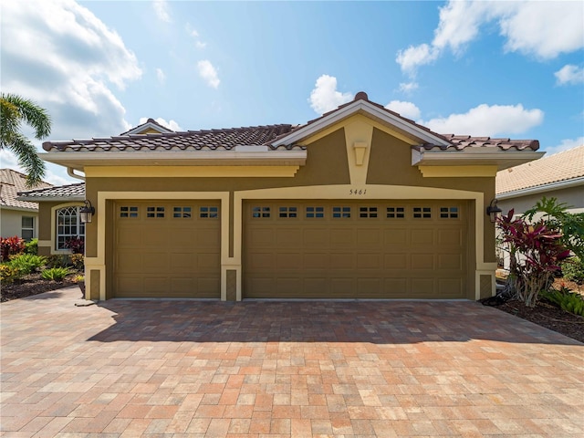 5461 White Ibis Dr, North Port, FL 34287 - view of front of property featuring driveway, stucco siding, a tiled roof, and a garage
