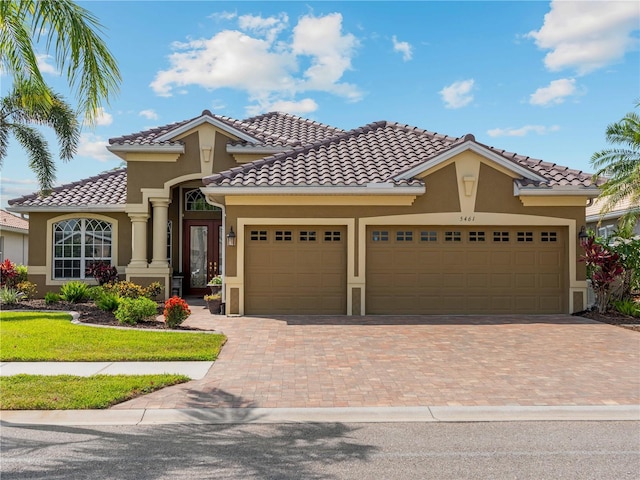 5461 White Ibis Dr, North Port, FL 34287 - mediterranean / spanish home featuring stucco siding, decorative driveway, an attached garage, and a tile roof