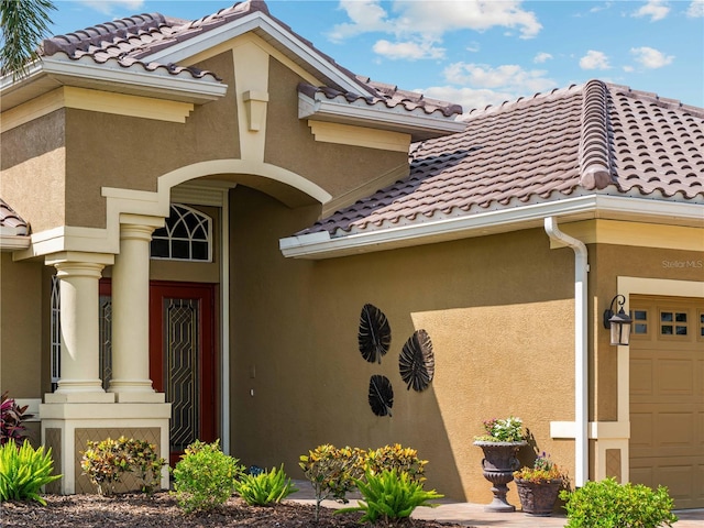 5461 White Ibis Dr, North Port, FL 34287 - view of exterior entry featuring a tiled roof, stucco siding, and a garage
