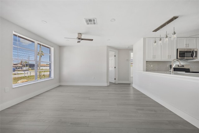 10517 Greenway Ave, Englewood, FL 34224 - unfurnished living room featuring a ceiling fan, light wood finished floors, baseboards, and recessed lighting