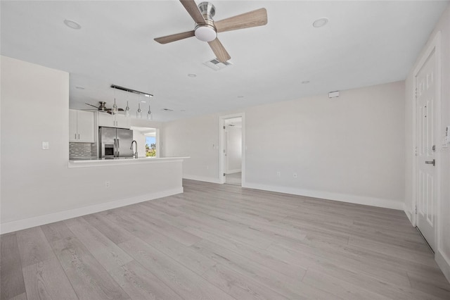 10517 Greenway Ave, Englewood, FL 34224 - unfurnished living room with ceiling fan, light wood finished floors, baseboards, and a sink