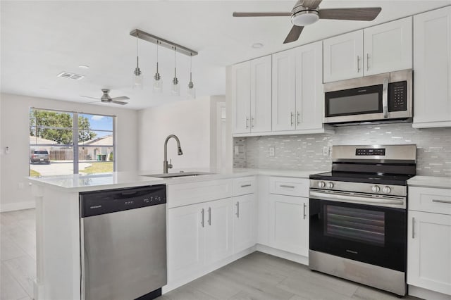 10517 Greenway Ave, Englewood, FL 34224 - kitchen featuring appliances with stainless steel finishes, a sink, a ceiling fan, a peninsula, and light countertops
