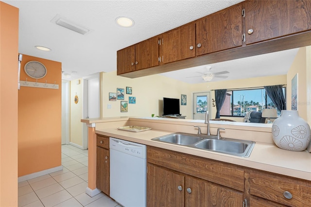 3160 Matecumbe Key Rd Unit 238, Punta Gorda, FL 33955 - kitchen featuring white dishwasher, a sink, light countertops, light tile patterned flooring, and brown cabinetry