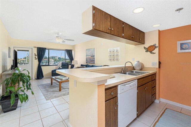 3160 Matecumbe Key Rd Unit 238, Punta Gorda, FL 33955 - kitchen with white dishwasher, a sink, a peninsula, light tile patterned flooring, and light countertops