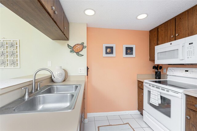 3160 Matecumbe Key Rd Unit 238, Punta Gorda, FL 33955 - kitchen featuring white appliances, a sink, light countertops, light tile patterned flooring, and a textured ceiling