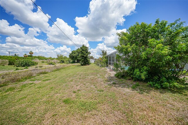 2193 Beacon Dr, Port Charlotte, FL 33952 - view of grassy yard featuring a lanai
