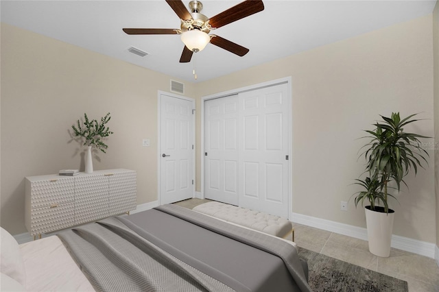 bedroom with baseboards, a closet, a ceiling fan, and light tile patterned flooring