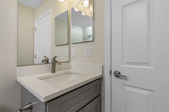 bathroom featuring vanity and a textured wall