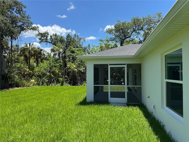 view of grassy yard with a sunroom