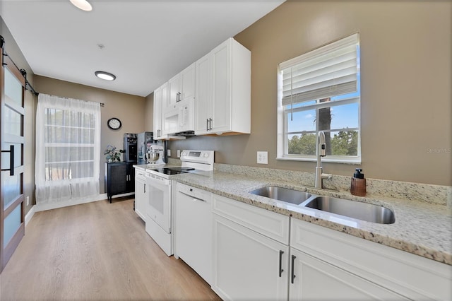 2160 Heron Lake Dr Unit 201, Punta Gorda, FL 33983 - kitchen featuring white appliances, a sink, light wood-style floors, white cabinets, and light stone counters