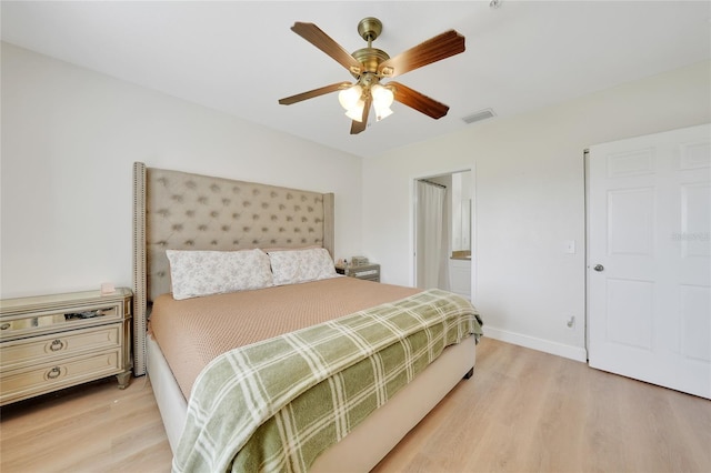2160 Heron Lake Dr Unit 201, Punta Gorda, FL 33983 - bedroom featuring light wood finished floors, baseboards, ceiling fan, and connected bathroom
