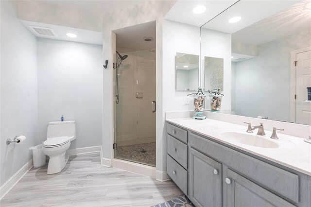 3329 Sunset Key Cir Unit 107, Punta Gorda, FL 33955 - bathroom with toilet, a shower stall, vanity, wood finished floors, and baseboards