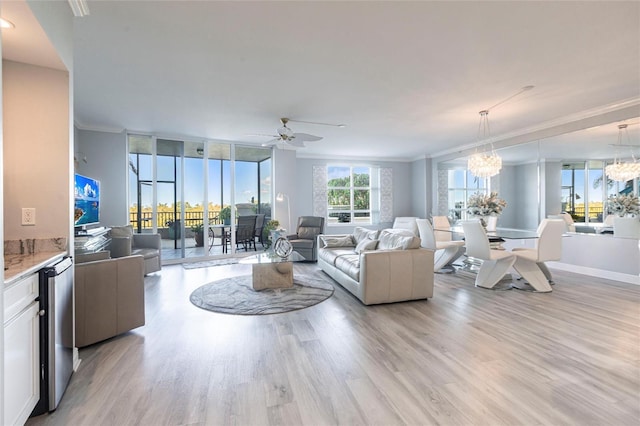 3329 Sunset Key Cir Unit 107, Punta Gorda, FL 33955 - living area featuring crown molding, light wood-type flooring, a chandelier, a ceiling fan, and baseboards