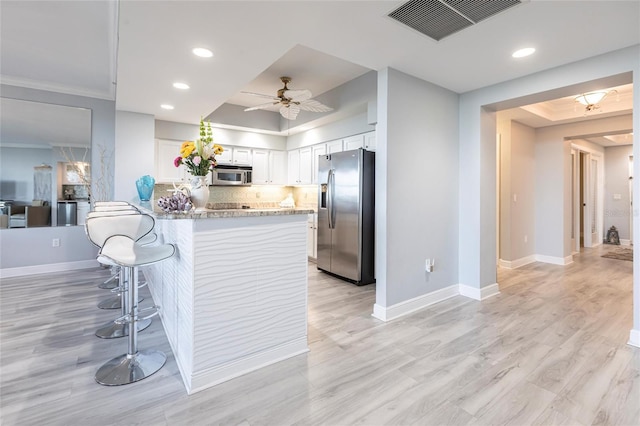3329 Sunset Key Cir Unit 107, Punta Gorda, FL 33955 - kitchen featuring stainless steel appliances, a tray ceiling, white cabinets, a peninsula, and ceiling fan