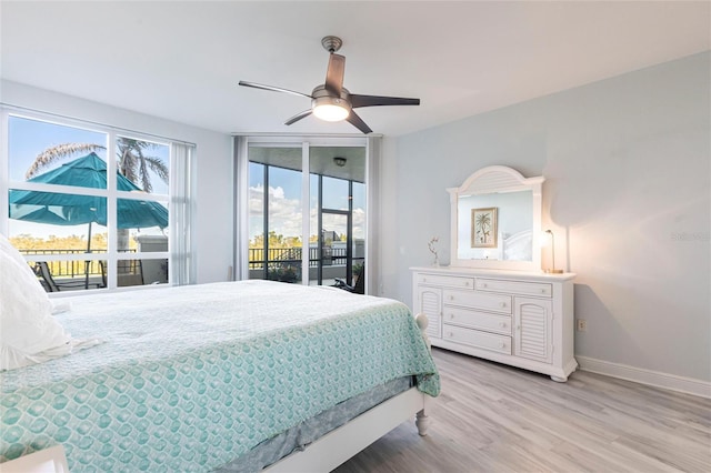 3329 Sunset Key Cir Unit 107, Punta Gorda, FL 33955 - bedroom featuring access to exterior, wood finished floors, baseboards, and a ceiling fan