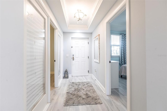3329 Sunset Key Cir Unit 107, Punta Gorda, FL 33955 - foyer entrance with ornamental molding, light wood-style flooring, a raised ceiling, a chandelier, and baseboards