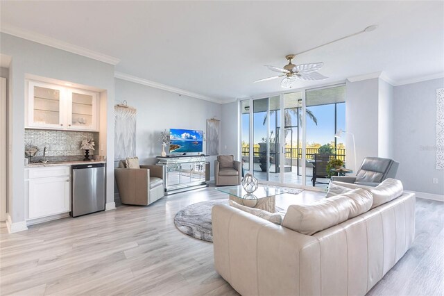 3329 Sunset Key Cir Unit 107, Punta Gorda, FL 33955 - living room with light wood finished floors, ceiling fan, ornamental molding, wet bar, and baseboards