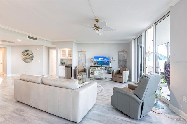 3329 Sunset Key Cir Unit 107, Punta Gorda, FL 33955 - living room with healthy amount of natural light, ceiling fan, baseboards, crown molding, and light wood-style floors