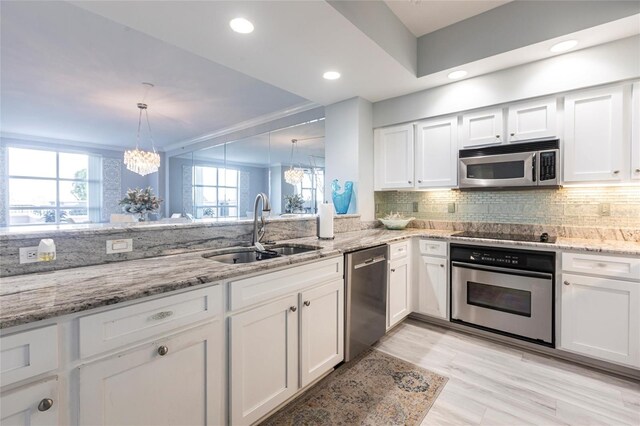 3329 Sunset Key Cir Unit 107, Punta Gorda, FL 33955 - kitchen featuring appliances with stainless steel finishes, a sink, white cabinetry, decorative backsplash, and recessed lighting