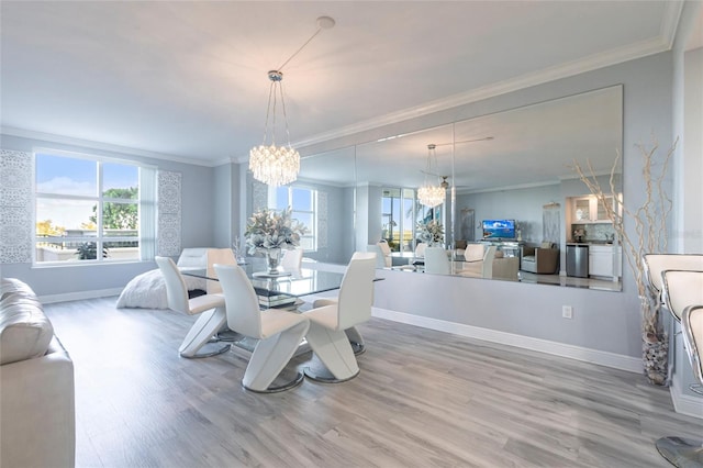 3329 Sunset Key Cir Unit 107, Punta Gorda, FL 33955 - dining area featuring a chandelier, crown molding, light wood-style flooring, and baseboards
