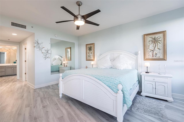 3329 Sunset Key Cir Unit 107, Punta Gorda, FL 33955 - bedroom featuring light wood-style floors, baseboards, connected bathroom, and a ceiling fan