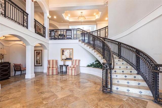3329 Sunset Key Cir Unit 107, Punta Gorda, FL 33955 - stairs featuring ornate columns, ornamental molding, marble tiled floors, arched walkways, and a towering ceiling