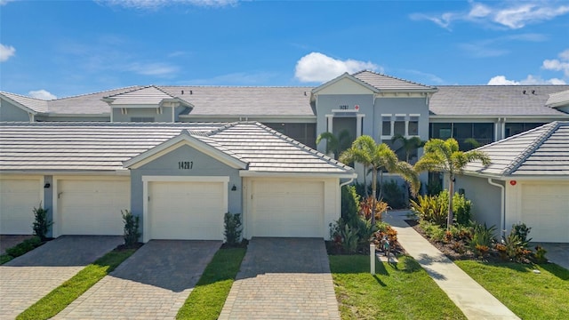 14267 Heritage Landing Blvd Unit 1223, Punta Gorda, FL 33955 - townhome / multi-family property with a tile roof, stucco siding, and community garages