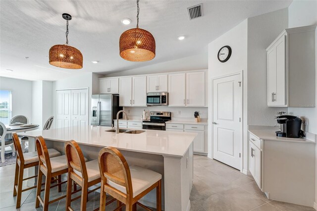 14267 Heritage Landing Blvd Unit 1223, Punta Gorda, FL 33955 - kitchen featuring appliances with stainless steel finishes, a sink, light countertops, a kitchen bar, and a center island with sink