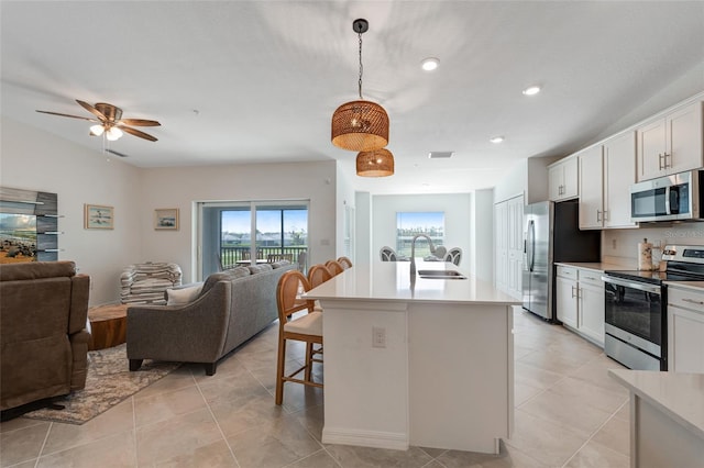 14267 Heritage Landing Blvd Unit 1223, Punta Gorda, FL 33955 - kitchen with appliances with stainless steel finishes, a sink, open floor plan, a kitchen bar, and light countertops