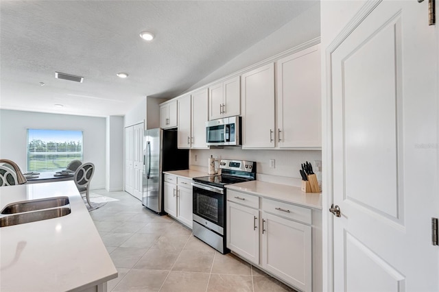 14267 Heritage Landing Blvd Unit 1223, Punta Gorda, FL 33955 - kitchen featuring stainless steel appliances, a sink, light countertops, white cabinets, and light tile patterned floors