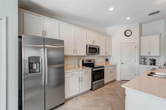 14267 Heritage Landing Blvd Unit 1223, Punta Gorda, FL 33955 - kitchen featuring stainless steel appliances, light countertops, light tile patterned floors, white cabinets, and a sink