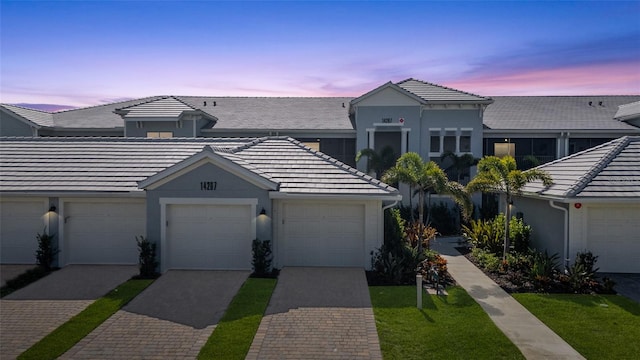 14267 Heritage Landing Blvd Unit 1223, Punta Gorda, FL 33955 - view of property with a tiled roof, decorative driveway, stucco siding, and a lawn