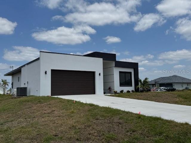view of front of home featuring a garage, stucco siding, concrete driveway, and cooling unit