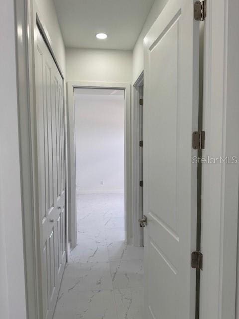 corridor with marble look tiles and recessed lighting