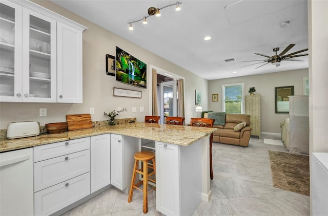 4231 Hollis Ave, Port Charlotte, FL 33953 - kitchen featuring a breakfast bar, a peninsula, white cabinetry, open floor plan, and glass insert cabinets