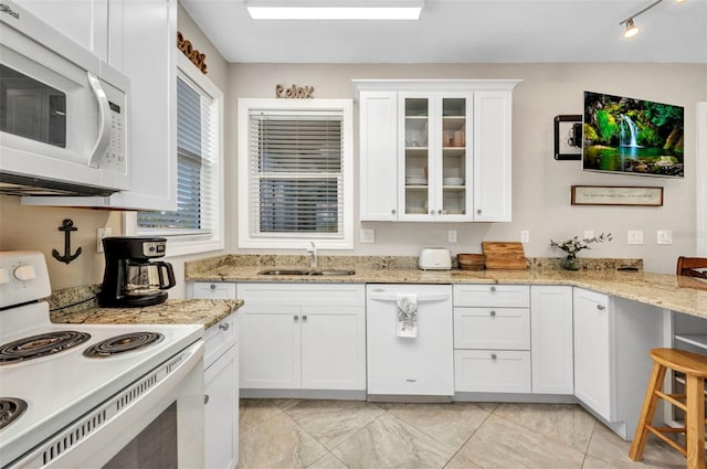 4231 Hollis Ave, Port Charlotte, FL 33953 - kitchen with white appliances, a sink, white cabinets, glass insert cabinets, and light stone countertops