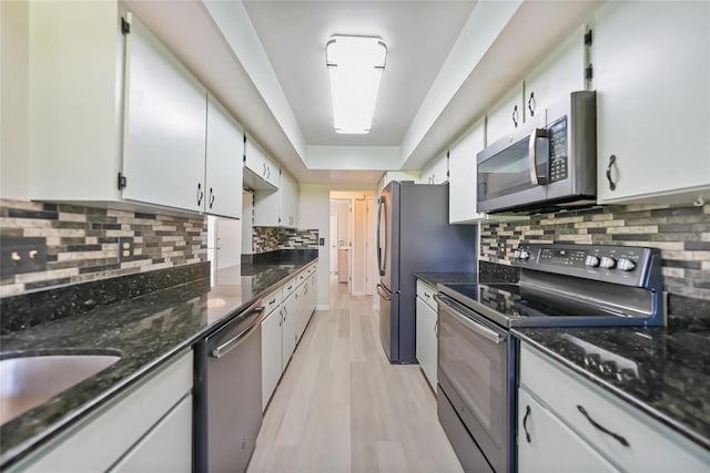 16615 Acapulco Rd, Punta Gorda, FL 33955 - kitchen featuring stainless steel appliances, backsplash, light wood-type flooring, white cabinets, and dark stone counters