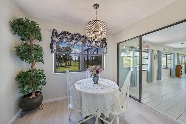 16615 Acapulco Rd, Punta Gorda, FL 33955 - dining room with a chandelier, light wood-style flooring, and baseboards
