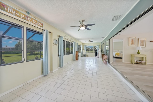 16615 Acapulco Rd, Punta Gorda, FL 33955 - unfurnished sunroom with a textured ceiling, plenty of natural light, tile patterned flooring, and baseboards